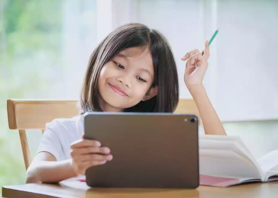 A Girl Taking Notes from Online Math Course on her Tablet Device with one Hand